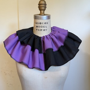 May include: A purple and black ruffled collar with the text "MODERN MODEL FORMS" printed on the front.