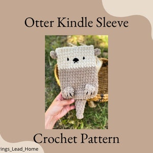 Op de afbeelding: Haakpatroon voor een Kindle-hoes in de vorm van een otter. De hoes is bruin en beige met een schattig ottergezicht. Het patroon is te koop.