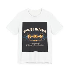 May include: White t-shirt featuring a graphic with the text "SYNAPSE HAPPENS" above an illustration of two cartoon neurons. Below the illustration is the text "It's not your fault. It's literally electrochemical."