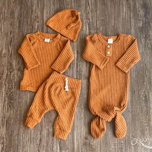 Fall newborn baby coming home outfit. Rust orange (copper) colored waffle knit long sleeve shirt, pants, tie hat and knotted baby gown in 0-3 months.