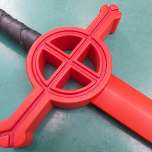 May include: A red plastic sword with a circular cross guard. The cross guard has a design of four circles within a larger circle.