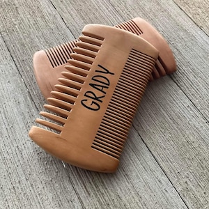 May include: A wooden comb with the name "Grady" engraved on it. The comb is brown and has a natural wood finish.