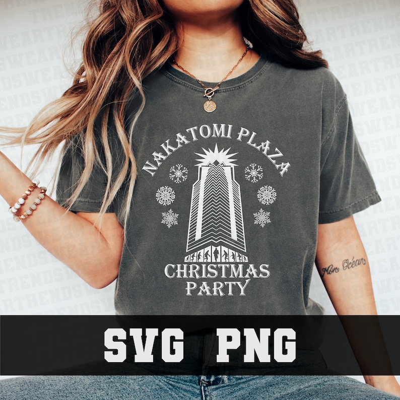 May include: Dark gray t-shirt with the text "NAKATOMI PLAZA CHRISTMAS PARTY" in white. The design features a skyscraper, snowflakes, and the text "SVG PNG" at the bottom. The shirt is a casual wear item.