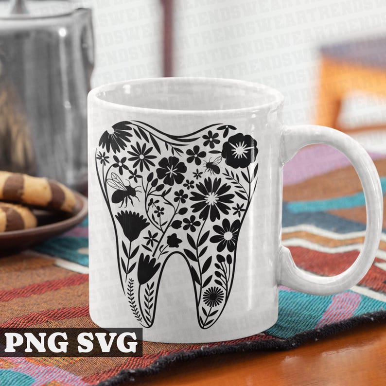 May include: White ceramic mug with a black silhouette of a tooth surrounded by flowers and bees. The mug has a black handle.