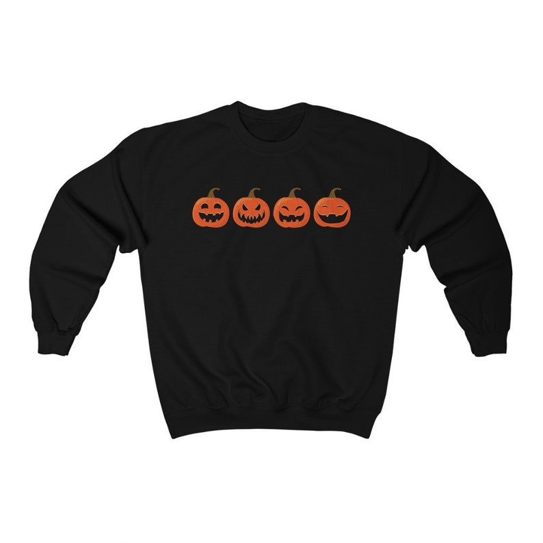 K&ouml;nnte beinhalten: Schwarzes Sweatshirt mit vier orangefarbenen K&uuml;rbisgesichtern mit unterschiedlichen Ausdr&uuml;cken. Die K&uuml;rbisse sind horizontal angeordnet. Das Sweatshirt besteht aus weichem Material, ideal f&uuml;r Halloween. Ein einfaches Design.