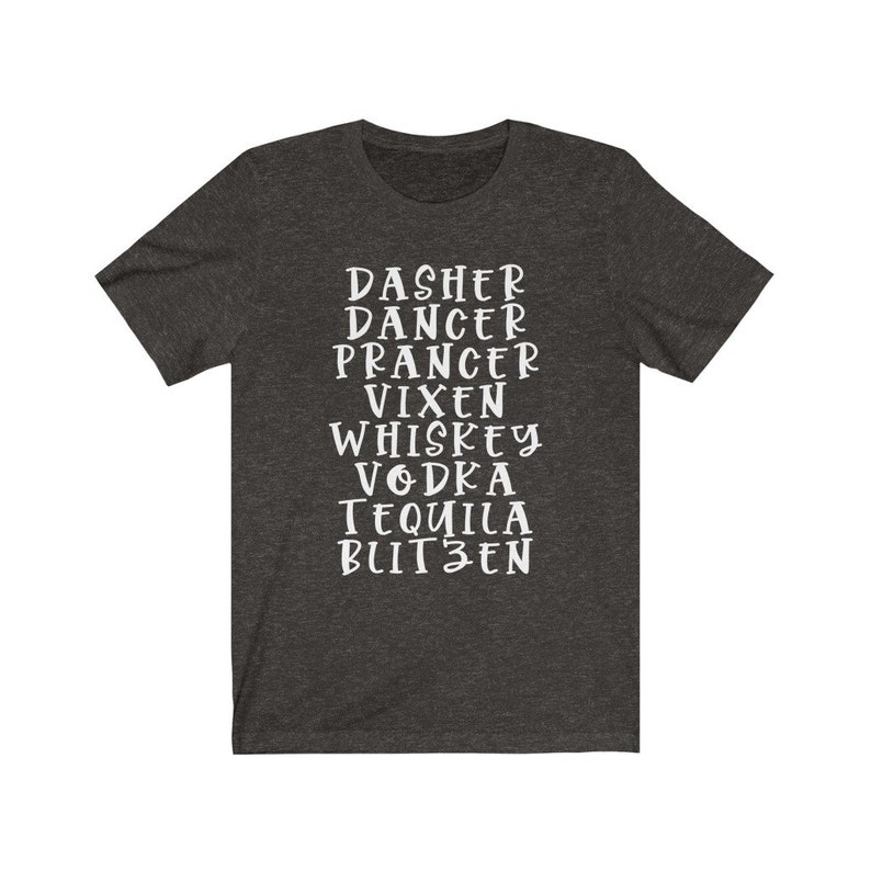 May include: Dark grey t-shirt featuring white text with festive words: Dasher, Dancer, Prancer, Vixen, Whiskey, Vodka, Tequila, and Blitzen. The shirt is made of a soft material and has short sleeves.