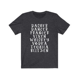 May include: Dark grey t-shirt with white text listing reindeer names and alcoholic beverages: Dasher, Dancer, Prancer, Vixen, Whiskey, Vodka, Tequila, and Blitzen. A casual tee for the festive season.