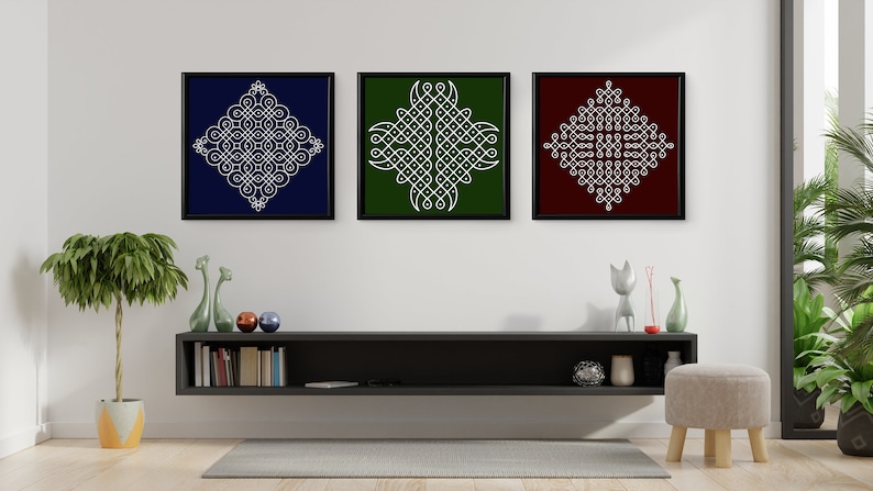 May include: Three framed square prints with white geometric designs on different colored backgrounds. The prints are hanging on a white wall above a black shelf with books and decorative objects.