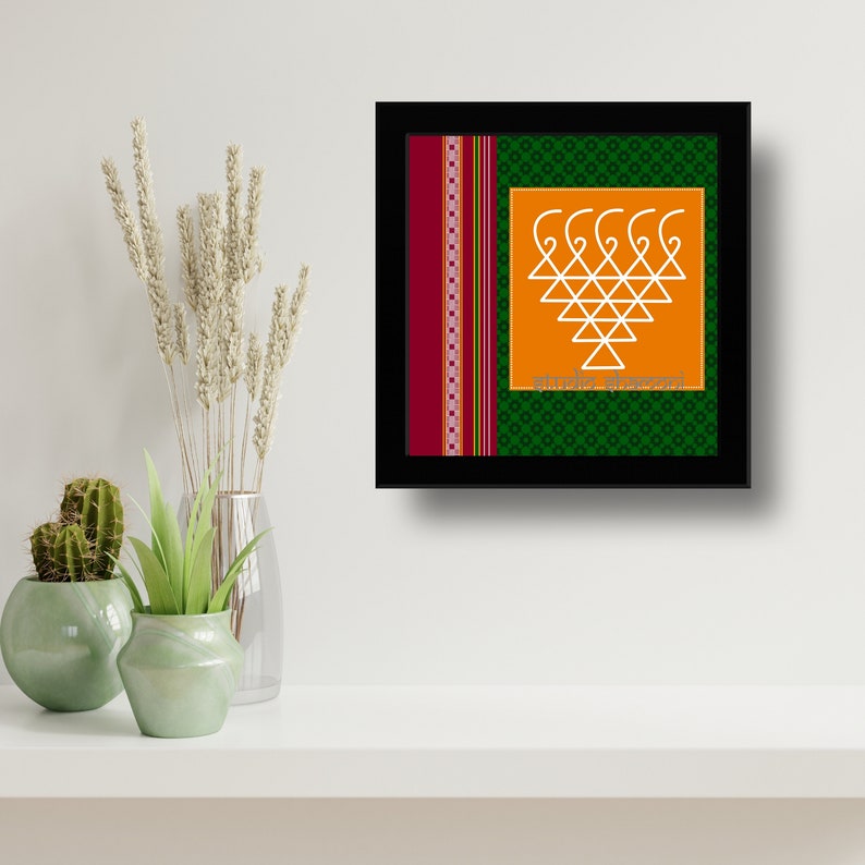 Op de afbeelding: Een ingelijst afdruk met een wit geometrisch ontwerp op een oranje achtergrond. Het ontwerp is omgeven door een groene rand met een herhalend patroon. De tekst "Sri Yantra - Shree Yantra" is onder het ontwerp gedrukt.