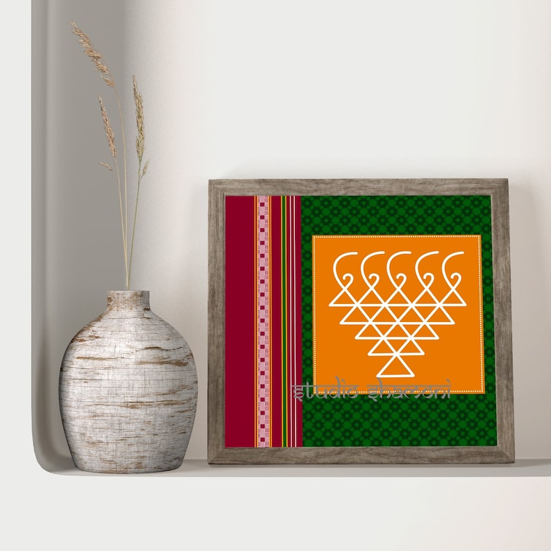 Op de afbeelding: Een ingelijst drukwerk met een wit geometrisch ontwerp op een oranje achtergrond. De lijst heeft een gepatroneerde rand in groen en rood. De tekst "studio abhayan" staat onderaan de print.