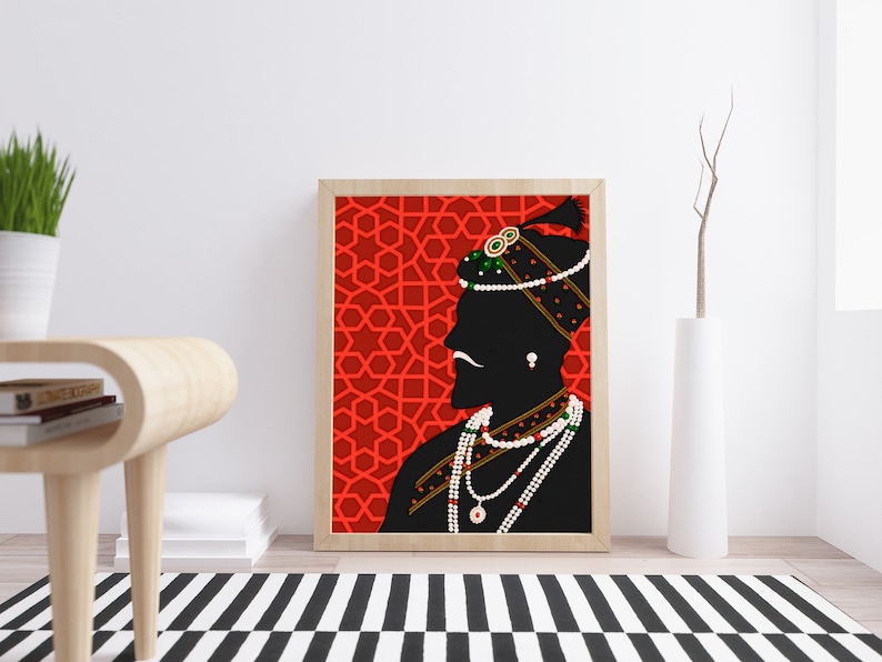 May include: A framed illustration of a silhouette of a person wearing a turban and jewelry against a red background with a geometric pattern.