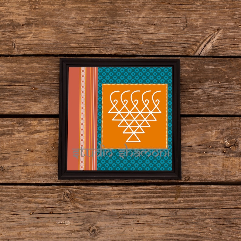 Op de afbeelding: Een ingelijst drukwerk met een wit geometrisch ontwerp op een oranje achtergrond. De lijst is zwart en de passe-partout is teal met een witte en rode gepatroneerde rand.