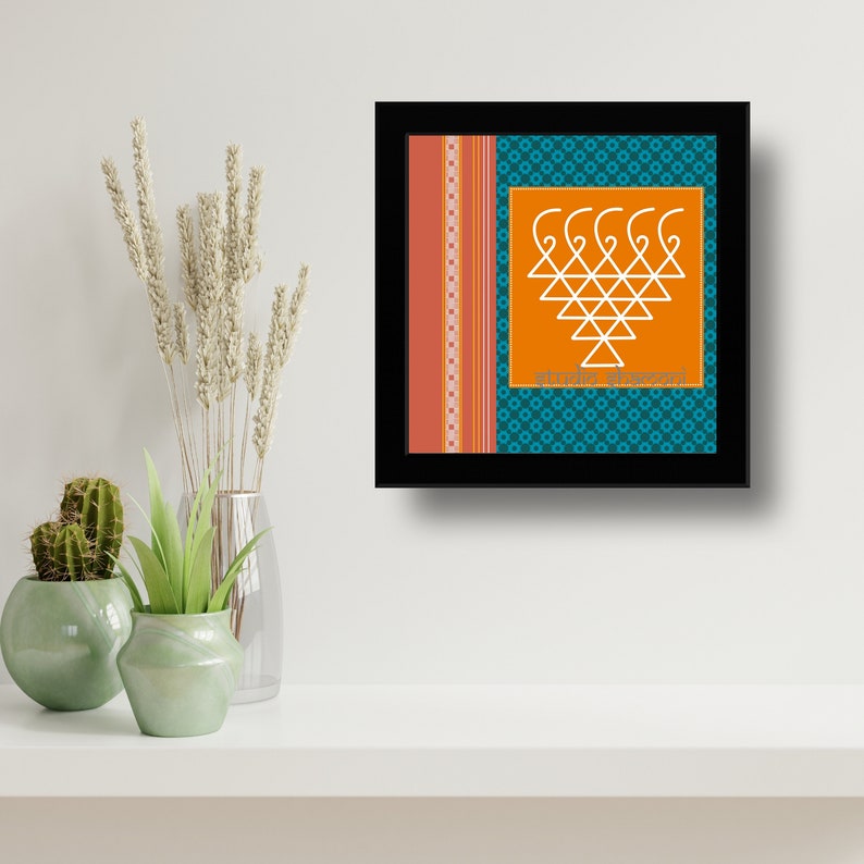 Op de afbeelding: Een ingelijste print met een wit geometrisch ontwerp op een oranje achtergrond. Het ontwerp is omgeven door een turquoise rand met een herhalend patroon. De tekst "Sri Yantra" staat in donkerblauwe letters onderaan de print.