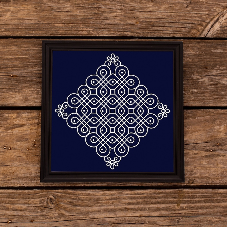 May include: A white geometric design on a dark blue background, framed in black. The design is a symmetrical pattern of circles and lines, creating a complex and intricate mandala-like shape.