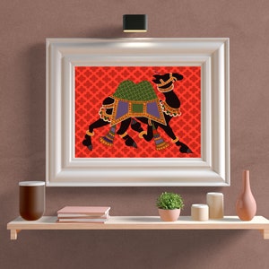 May include: A framed print of a black camel with a green and purple saddle, set against a red background with a repeating pattern. The camel is depicted in a traditional Indian style.