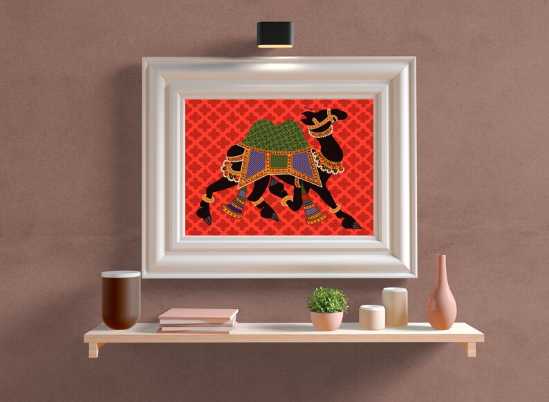May include: A framed print of a black camel with a green and purple saddle, set against a red background with a repeating pattern. The camel is depicted in a traditional Indian style.