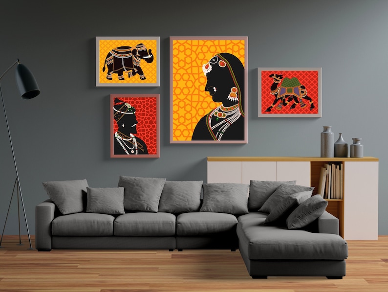 May include: Four framed prints with a yellow and orange geometric pattern, a black silhouette of an elephant, a black silhouette of a camel, and a black silhouette of a person wearing a turban and jewelry. The prints are hanging on a gray wall above a gray sectional sofa.