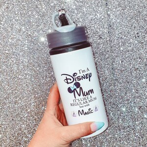 May include: White water bottle with a black lid and a black and white graphic that says "I'm a Disney Mum. It's like a regular mum but with magic." The graphic includes a Mickey Mouse head with a bow.