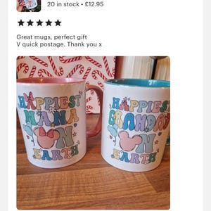May include: Two white ceramic mugs with colourful text and images. The mug on the left says "Happiest Nana on Earth" and features a pink Mickey Mouse head with a bow. The mug on the right says "Happiest Grandad on Earth" and features a pink Mickey Mouse head. Both mugs have a light blue and pink rim.