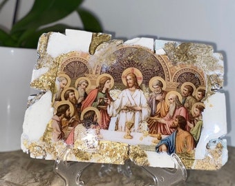 May include: A white, gold, and brown framed painting depicting Jesus Christ and his disciples at the Last Supper. The painting is on a white background with gold accents and is framed in a white, gold, and brown frame.