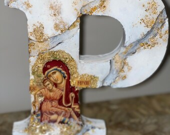Arte com inicial em madeira revestida de resina, com ícone de Nossa Senhora.