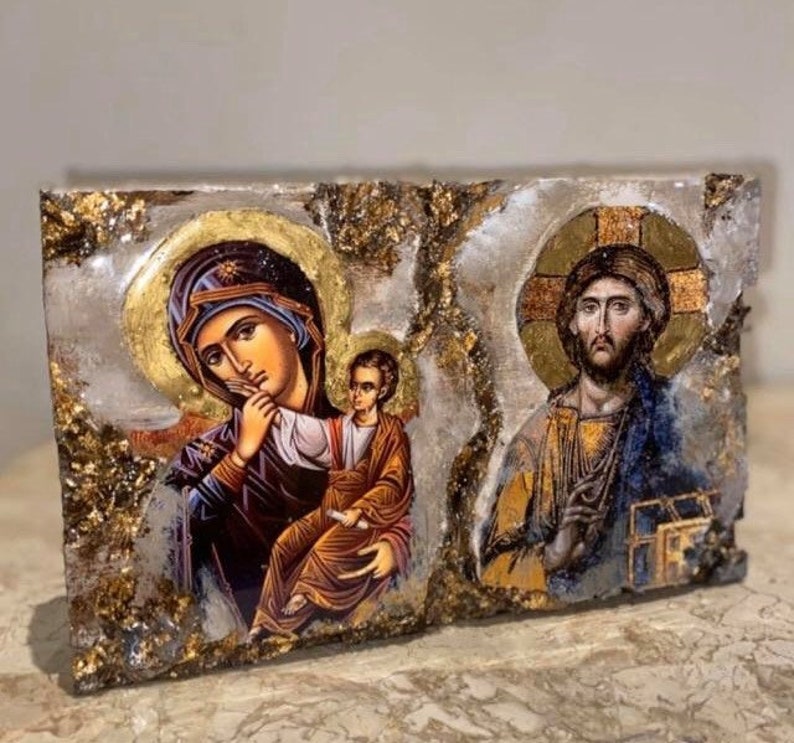 May include: A religious icon depicting the Virgin Mary holding a baby Jesus, with a gold background and a decorative frame. The icon is painted in a traditional style with vibrant colors.