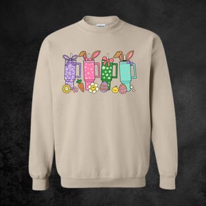 May include: A set of three ceramic mugs with a speckled, matte finish. The mugs are in shades of cream, light gray, and dark gray. Each mug has a simple, minimalist design, perfect for coffee or tea.