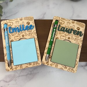 May include: Two wooden desk organizers with a pet-themed design. Each has a name cut-out, a notepad, and a pen. One has "Emilee" in blue, the other has "Lauren" in green. The pens are blue and green.