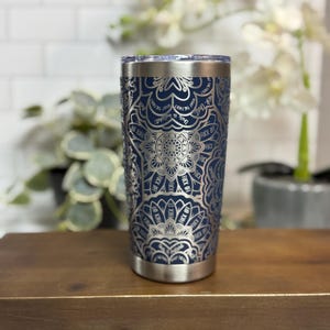 Puede incluir: Un vaso de acero inoxidable azul marino con un dise&ntilde;o de mandala plateado. El dise&ntilde;o incluye la frase "This is what the fuck I want" y "Fuck Off". El vaso tiene un borde y una base plateados.
