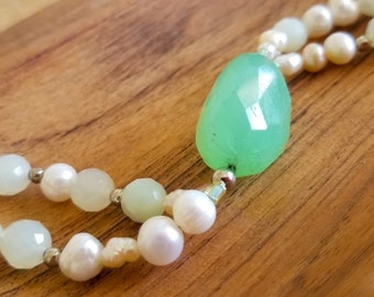 This bracelet features egg-shaped, green jade. Centered in delicate and elegant strands of fresh water pearls with sterling silver toggle.