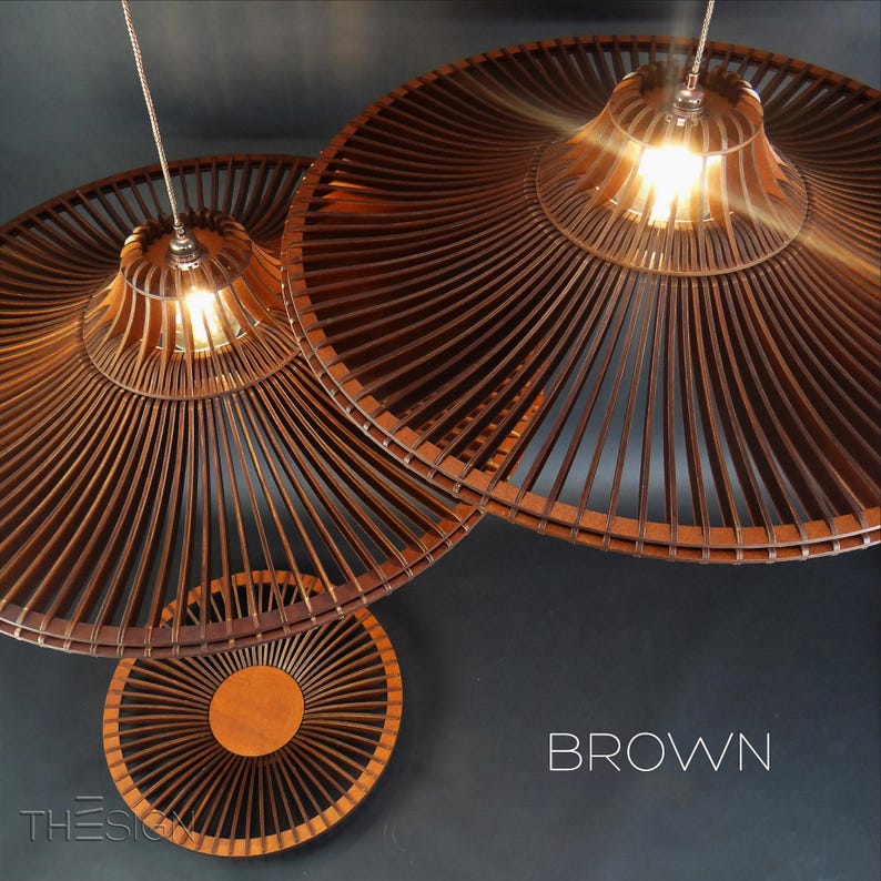 May include: Two brown wooden pendant lights with a woven design. The lights are hanging from the ceiling and are illuminated. The word "BROWN" is written in white letters on a dark background.