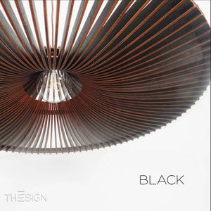 May include: A black, wooden, ceiling light fixture with a unique, spiral design. The light fixture is made of thin, wooden slats that are arranged in a spiral pattern. The light fixture is lit by a single light bulb.