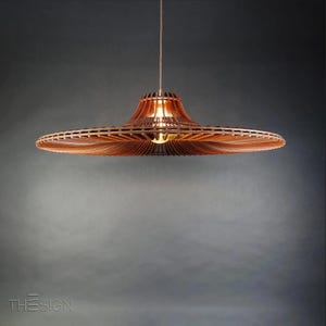 May include: A wooden pendant light with a wide, flat, circular shade. The shade is made of thin, wooden slats that are arranged in a radial pattern. The light is hanging from a single cord.
