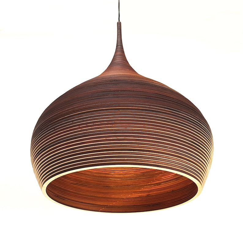 May include: A brown wooden pendant light with a rounded, layered shade. The light is suspended from a black cord.