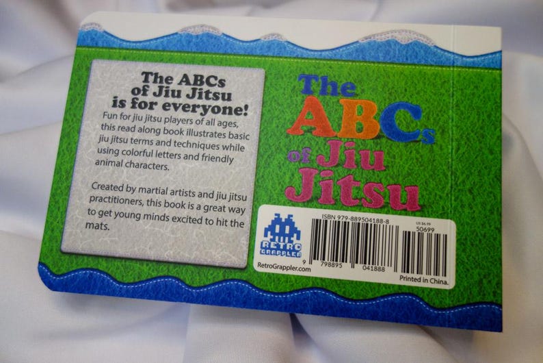 May include: The back cover of a children's book titled "The ABCs of Jiu Jitsu is for everyone!"  The book cover is green with a blue wave border. The book cover features a colorful illustration of the letters ABC and the words "Jiu Jitsu". The book cover also includes an ISBN number, a barcode, and the text "Printed in China."