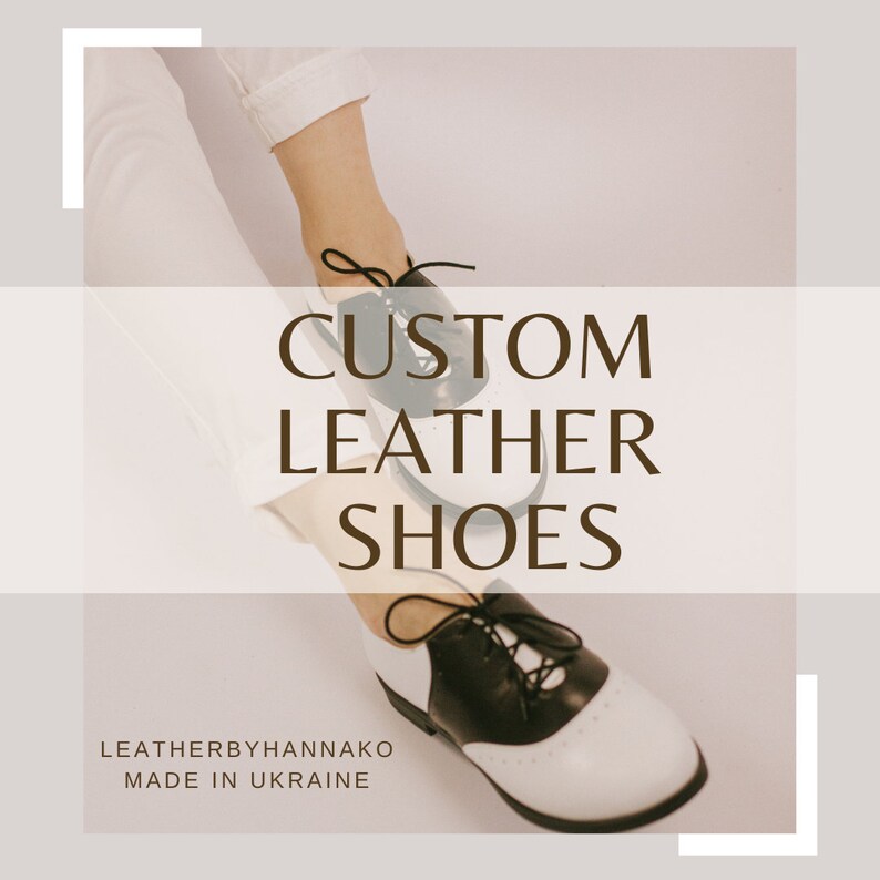 K&ouml;nnte beinhalten: Ma&szlig;gefertigte Lederschuhe in Schwarz und Wei&szlig;, mit klassischem Oxford-Design. Die Schuhe haben schwarze Schn&uuml;rsenkel und eine perforierte Zehenkappe. Der Text "CUSTOM LEATHER SHOES" ist in brauner Schrift dargestellt. Die Marke ist "LEATHERBYHANNAKO".