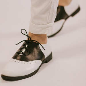 These handcrafted leather Oxford shoes combine classic American saddle shoe design with modern comfort and durability. Available in custom leather colors, wide-width fitting, and personalized sizes, they make a unique gift for women who love vintage fashion, timeless craftsmanship, and comfortable handmade leather footwear.