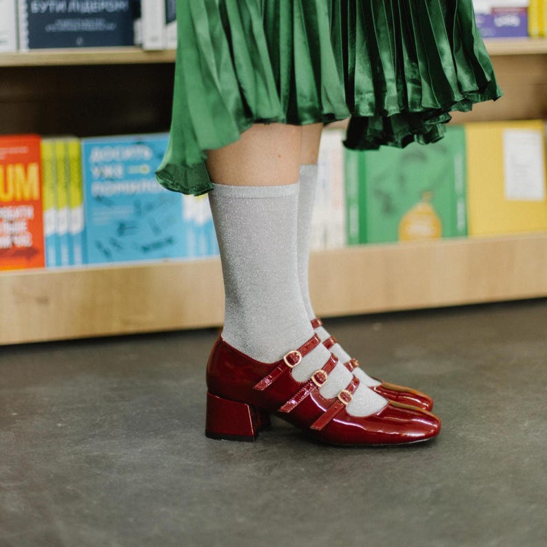 Introducing our stunning Burgundy Patent Leather Mary Janes, a bold reinterpretation of a timeless classic. These shoes are handcrafted from glossy genuine patent leather in a rich wine-red tone, designed for women who embrace vintage aesthetics with a modern twist. Featuring four slim buckled straps, a square toe, and a comfortable mid block heel, they blend retro charm with everyday wearability.