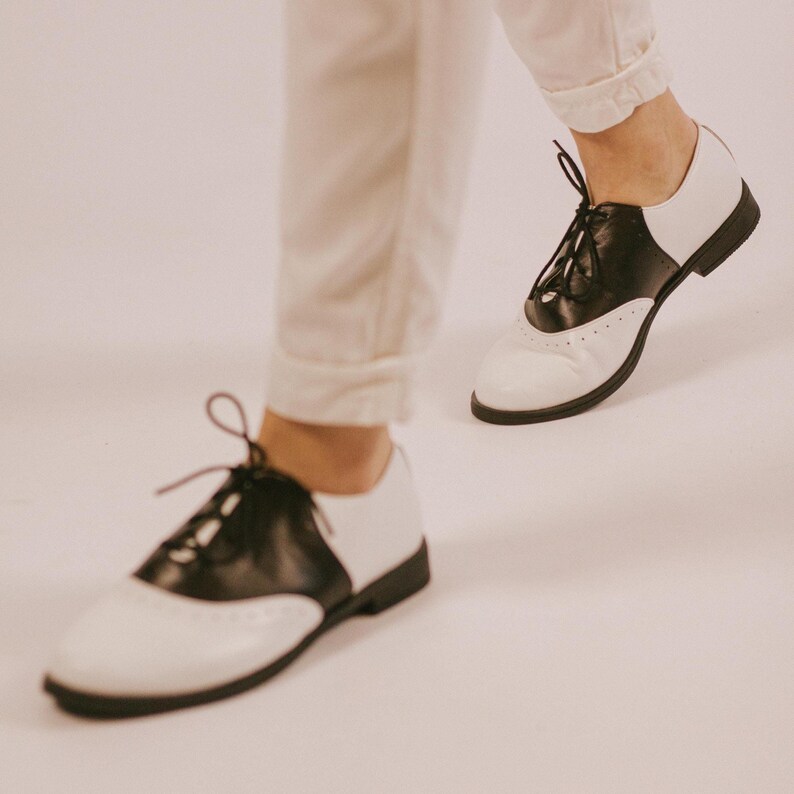 These black and white oxford shoes are made for those who love timeless style with a bold edge.
A perfect balance between masculine structure and feminine elegance, this design creates a strong, confident silhouette while staying minimal and effortless. The contrast of black and white leather makes them stand out without being loud — a statement piece you can wear every day.
Whether styled with trousers, denim, or a dress — they instantly elevate your look.
