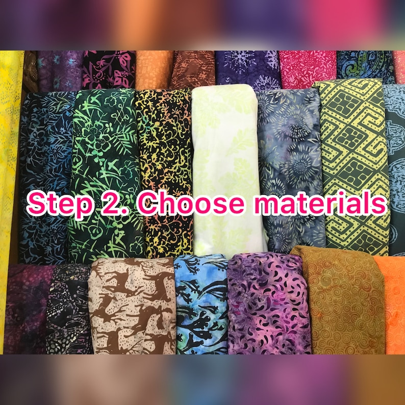 May include: A display of colorful fabric rolls with various patterns, including floral, geometric, and abstract designs. The text "Step 2. Choose materials" is overlaid on the image, suggesting a selection process. The fabrics are in shades of green, blue, purple, and orange.