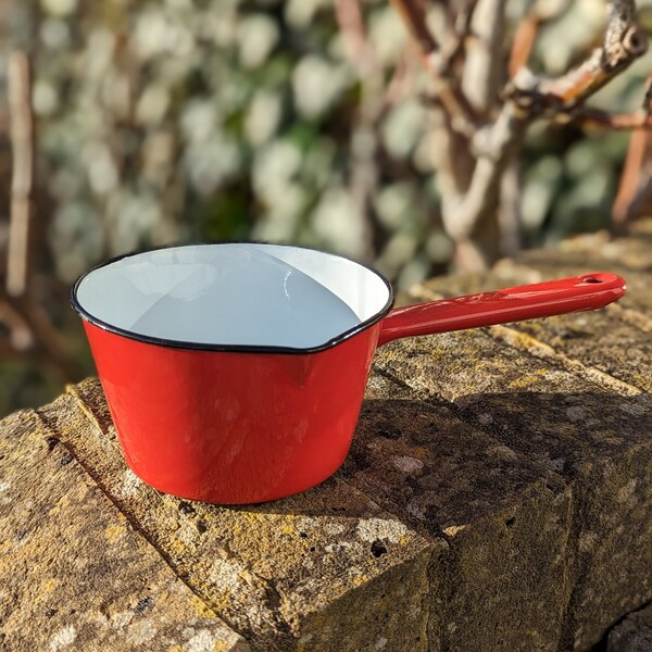 Small red enamel milk pan with handle and black trim. Argyle Domestic Wares