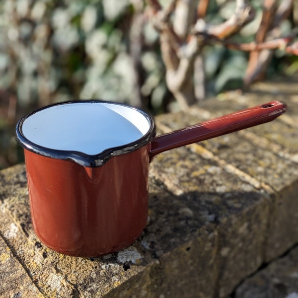 Small brown enamel pan with black trim and handle