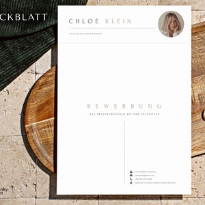 May include: A white cover letter with the text "DECKBLATT" and "CHLOE KLEIN" at the top. The text "PERSONALREFERENT" is below the name. The text "BEWERBUNG" is in the center of the page with the text "ALS PROJEKTMANAGER BEI DER SALZGITTER" below it. The text "17.03.1989 in Hamburg" is in the bottom left corner of the page. The text "Katharina-von-Bora-Stra&szlig;e 1, 80333 M&uuml;nchen" is in the bottom right corner of the page.