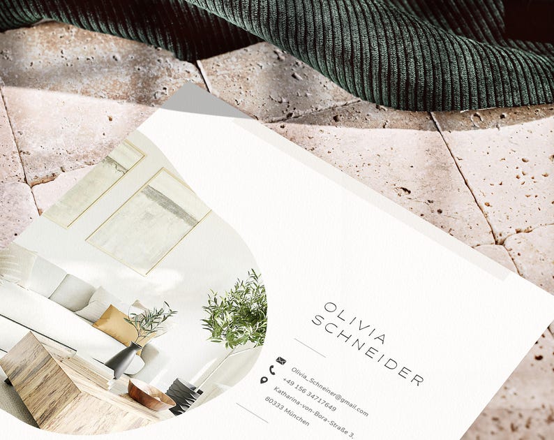 Pode incluir: Um cart&atilde;o de visita com o nome "OLIVIA SCHNEIDER" impresso em uma fonte minimalista. O cart&atilde;o apresenta informa&ccedil;&otilde;es de contato, incluindo um endere&ccedil;o de e-mail e um n&uacute;mero de telefone. O fundo inclui um vislumbre de um design de interiores moderno e um tecido verde.