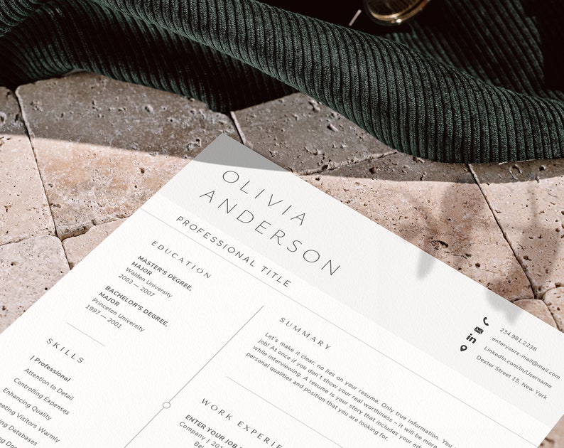 May include: A resume with the name "OLIVIA ANDERSON" at the top. The resume includes sections for education, skills, and work experience. The resume is on a light-colored paper with a dark green fabric in the background.