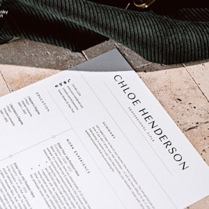 May include: A white resume with black text. The resume is for Chloe Henderson. The resume includes a summary, education, and work experience sections. The resume is on a light brown tiled surface.
