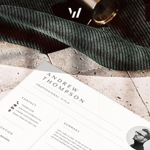 Puede incluir: Un curr&iacute;culum vitae profesional con el nombre "Andrew Thompson" se muestra sobre una superficie texturizada. El curr&iacute;culum incluye informaci&oacute;n de contacto, educaci&oacute;n y una secci&oacute;n de resumen. Un tejido verde oscuro y un objeto dorado est&aacute;n en el fondo.