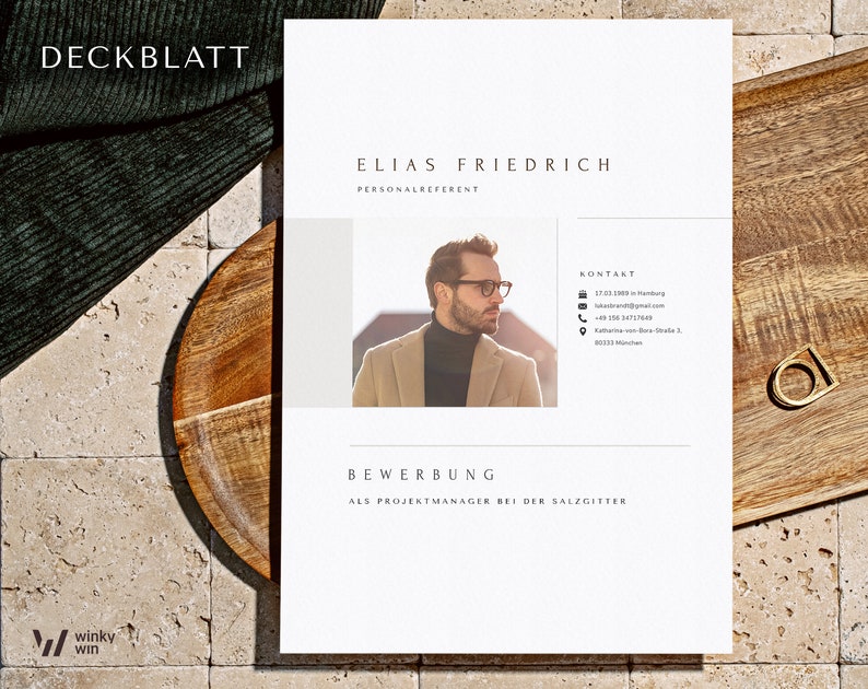 May include: A white resume template with the title "DECKBLATT" at the top. The resume is for Elias Friedrich, Personalreferent. The resume includes a professional headshot of Elias, contact information, and the text "BEWERBUNG ALS PROJEKTMANAGER BEI DER SALZGITTER".