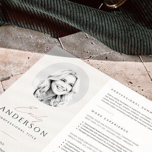 May include: A black and white photo of a woman smiling. The photo is in a circle on a white resume with the text "Emily Anderson" and "Professional Title" in a black font. The resume also includes a professional summary and work experience section.