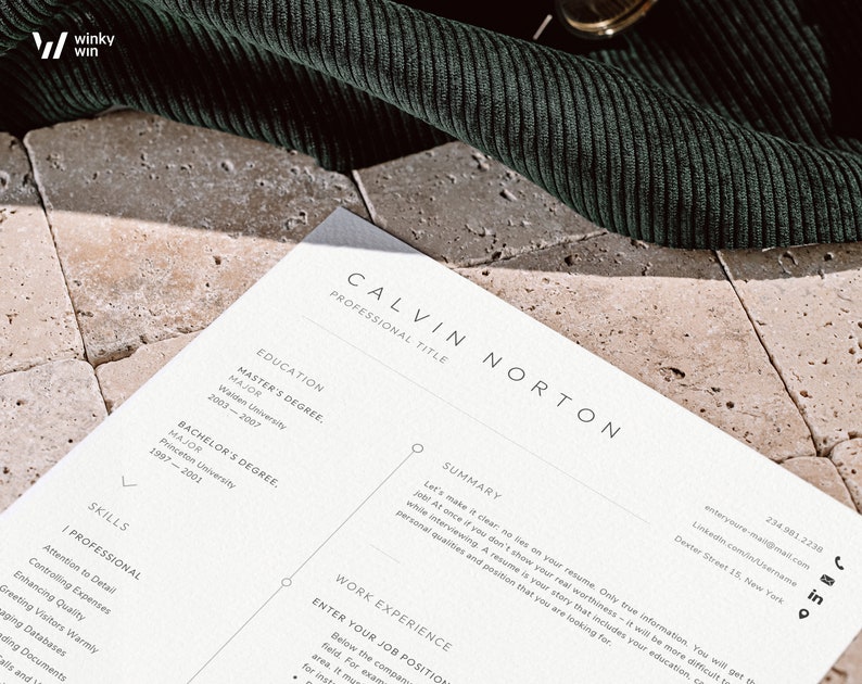 May include: A close-up of a resume with the name Calvin Norton at the top. The resume includes sections for education, work experience, and skills. The resume is printed on white paper and is lying on a textured surface.